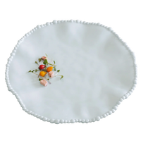 White decorative plate with small colorful flowers on a white background