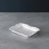 White ceramic dish with decorative edge on a gray surface
