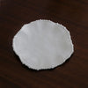 White ceramic plate with decorative edge on a dark wooden surface