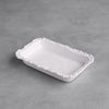 White ceramic tray with decorative edge on a gray surface