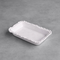 White ceramic tray with decorative edge on a gray surface