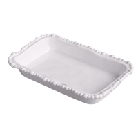White ceramic dish with decorative edge on a white background