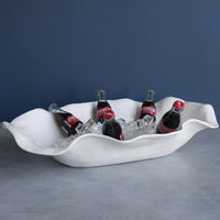 White wavy ice bucket with Coca-Cola bottles on a gray surface and blue background