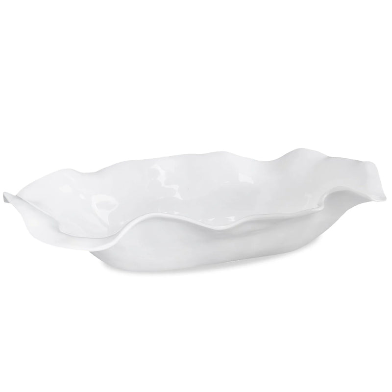 White ceramic serving dish with wavy edge on a white background