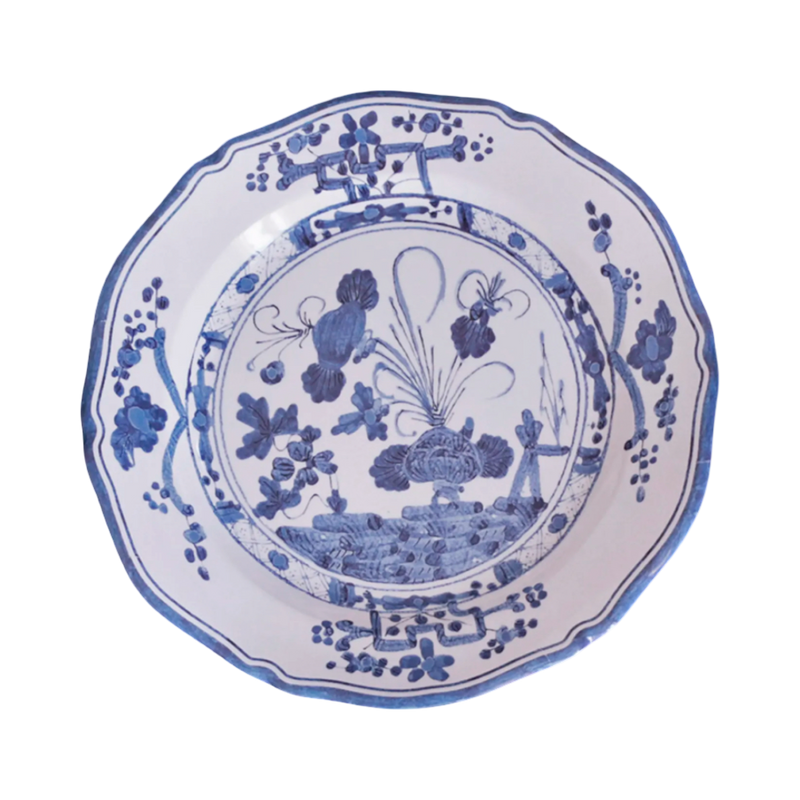 Blue and white decorative plate with floral and landscape design on a white background