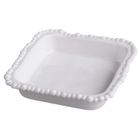 White ceramic dish with decorative edge on a white background