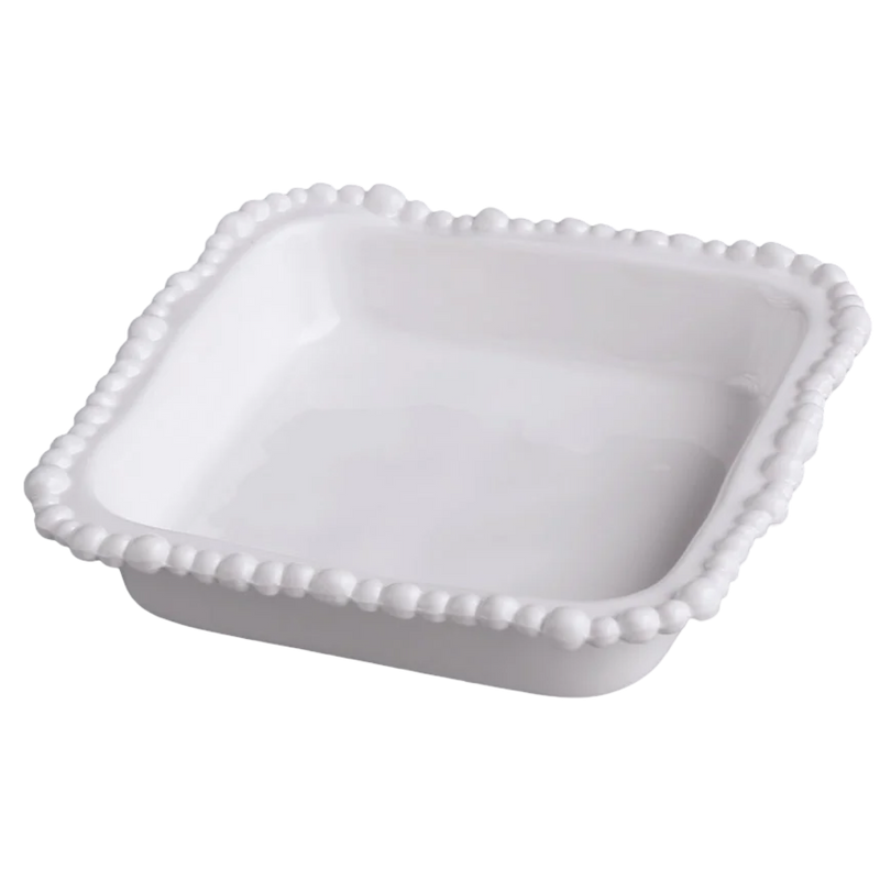 White ceramic dish with decorative edge on a white background