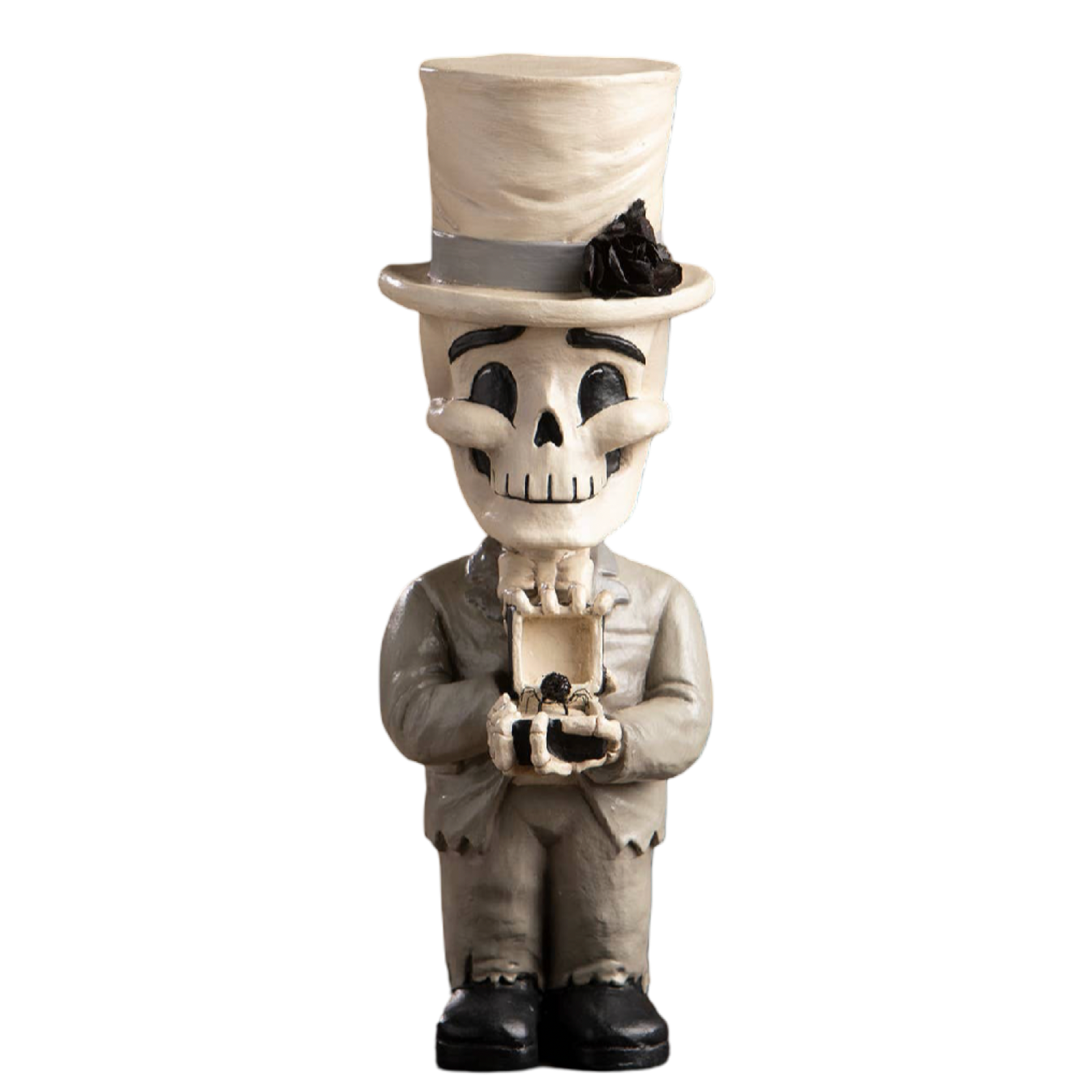 A decorative skeleton figurine styled as a man in a top hat and suit, holding a small box with a ring, photographed against a plain white background.