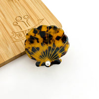 Brown tortoise seashell acetate hair claw clip with pearl-inspired center accent.