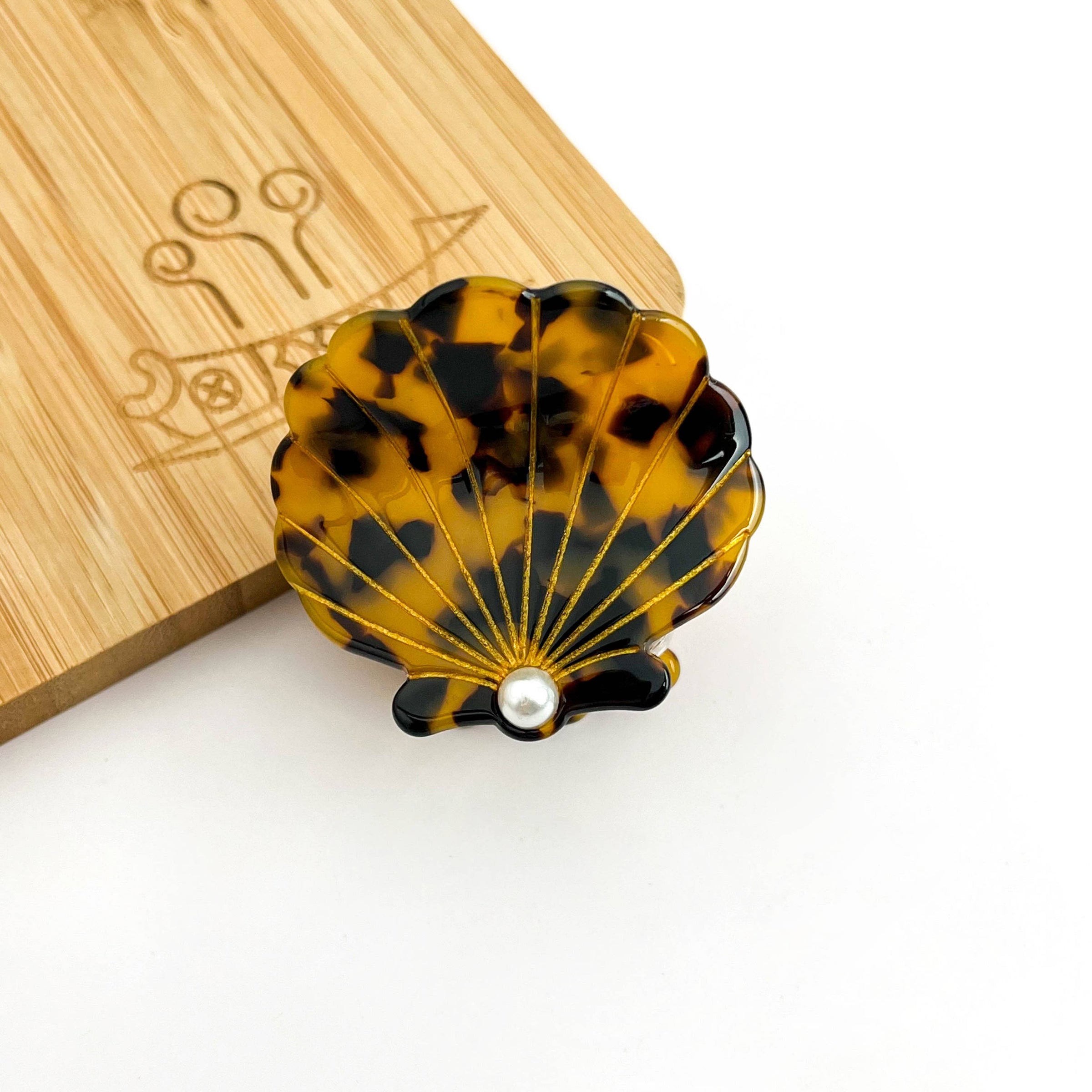 Brown tortoise seashell acetate hair claw clip with pearl-inspired center accent.