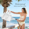Woman holding a white mesh bag under a shower of water on a beach with palm trees.