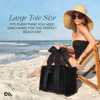 Woman on a beach with a large black tote bag, promotional text for a large tote size.