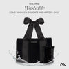 Black tote bag with a bow on a white background, featuring washing instructions.