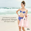 Woman in a blue bikini holding a pink bag on a beach with text about jacquard straps.