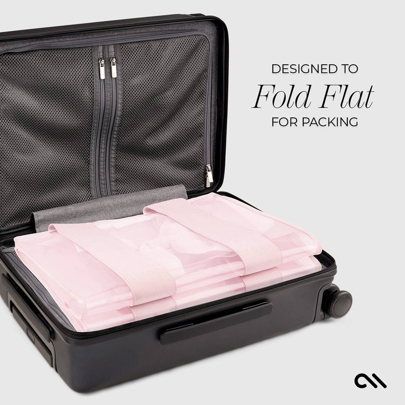 Black suitcase with pink folded fabric inside, labeled 'Designed to Fold Flat for Packing'.