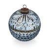 Decorative spherical box with intricate design and metallic lid on a white background