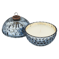 Decorative candle with a blue and white patterned holder on a white background