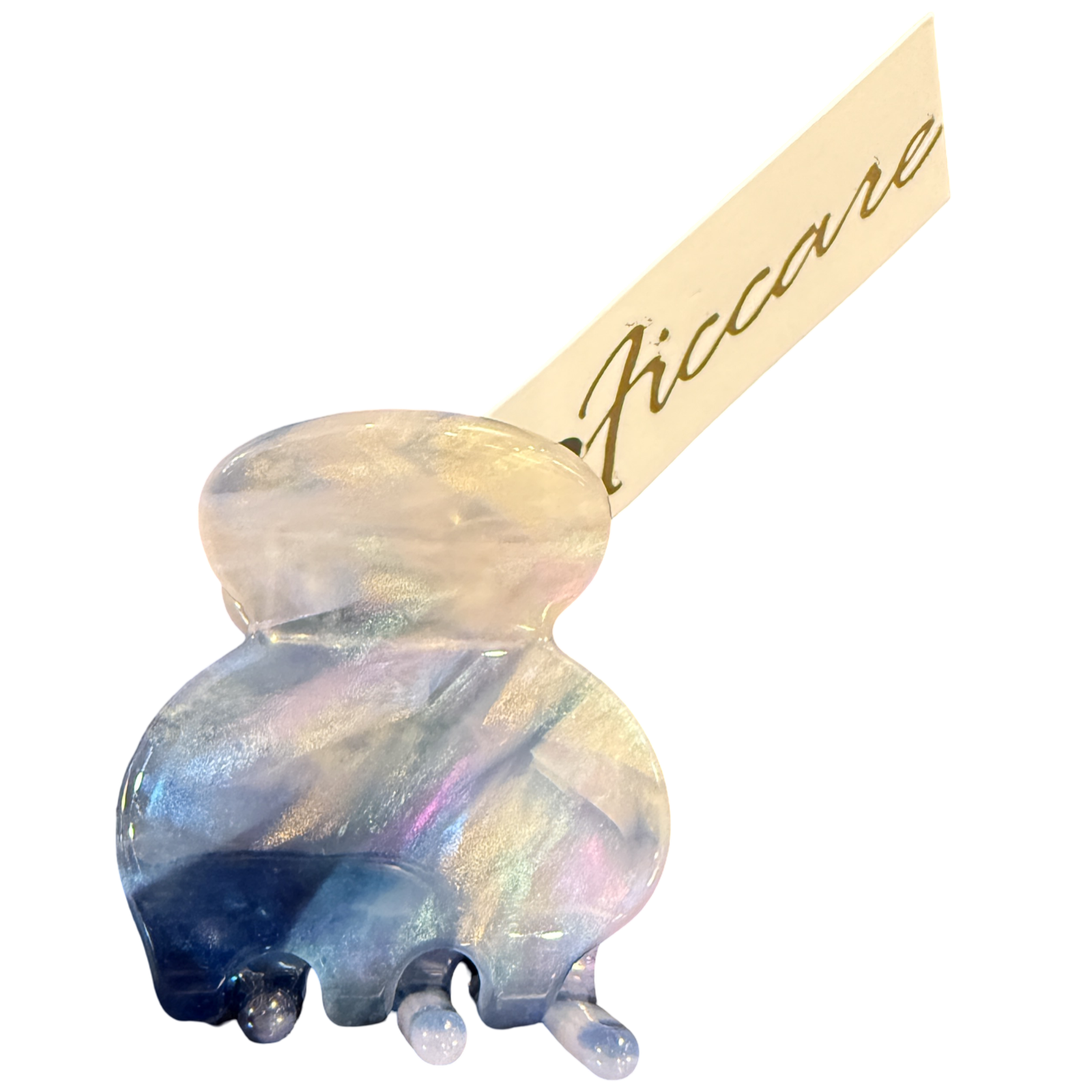 An iridescent jelly hair claw clip with a double-bulb design, featuring a holographic finish that shifts between blue, purple, and gold. A beige paper tag with the brand name 'Piccare' in gold script is attached to the clip, set against a plain white background.