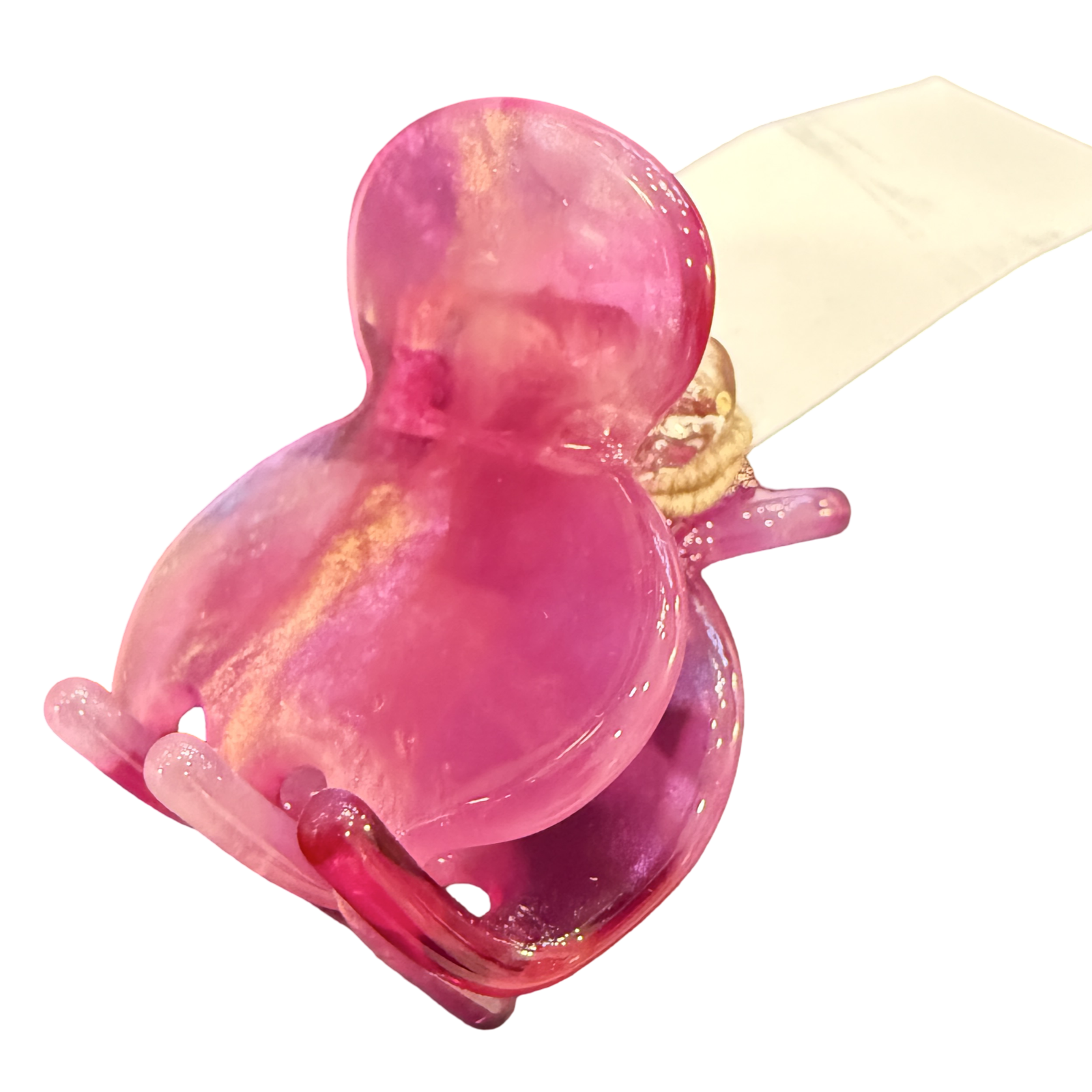 A translucent pink glass frog-shaped ring holder with a cream-colored ribbon wrapped around its neck, isolated on a white background.