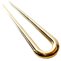 A polished gold-toned metal U-shaped clip or fork with a reflective finish, isolated on a white background.