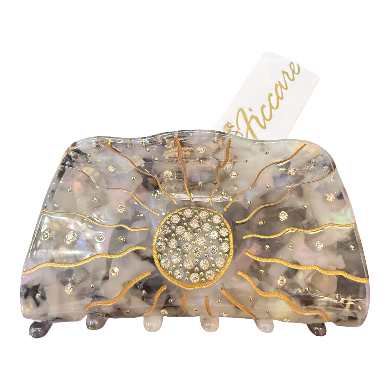 A large hair claw clip by Accare, featuring a translucent iridescent resin body with gold glitter sunburst lines, a central round rhinestone cluster, and small rhinestone accents, shown on a white background with a white paper tag.