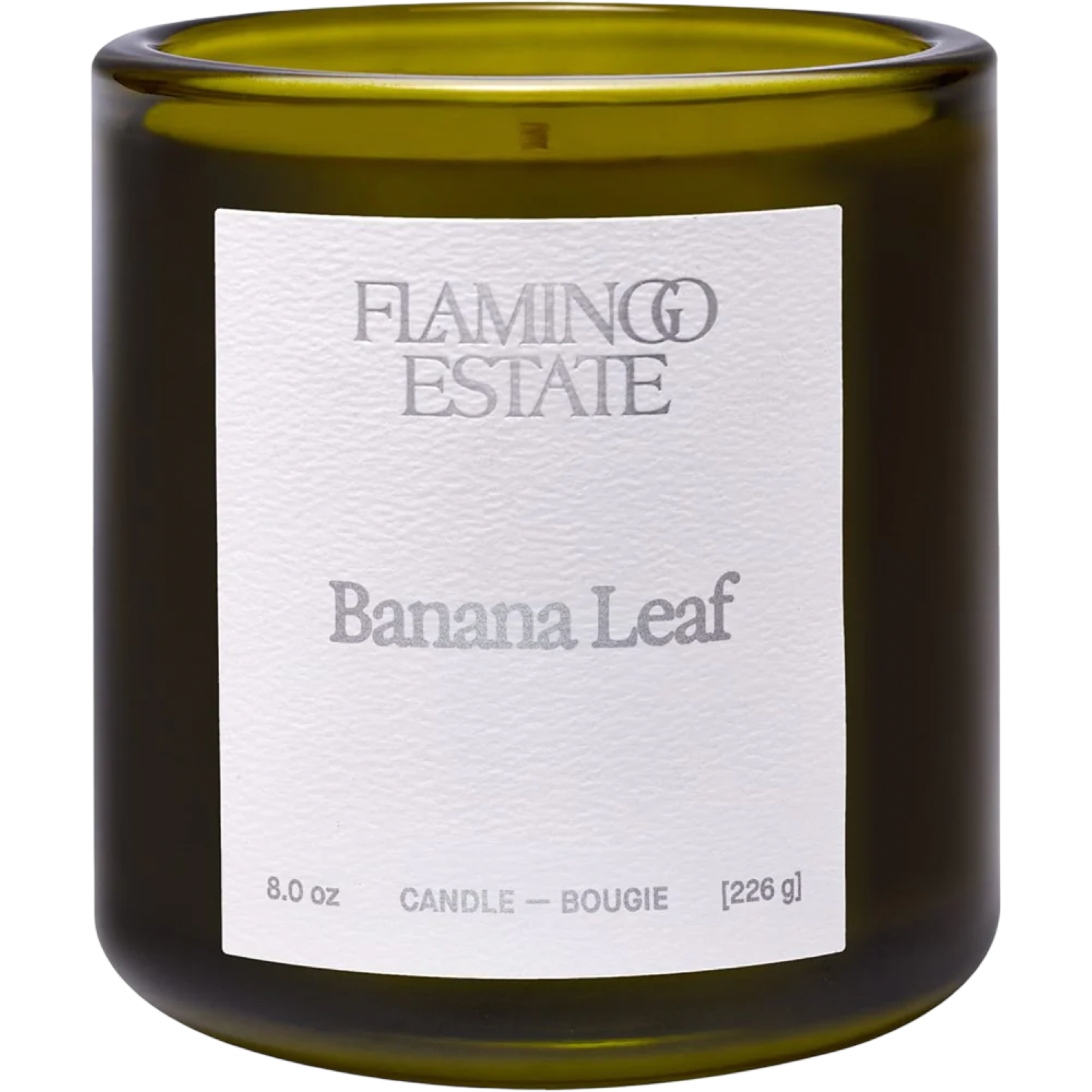 An 8.0 oz glass candle in a dark olive green jar with a white paper label reading 'FLAMING ESTATIE Banana Leaf'.
