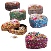 Five heart-shaped beaded jewelry boxes in different colors, decorated with colorful rhinestones and one open box showing rings inside, on a plain white background.