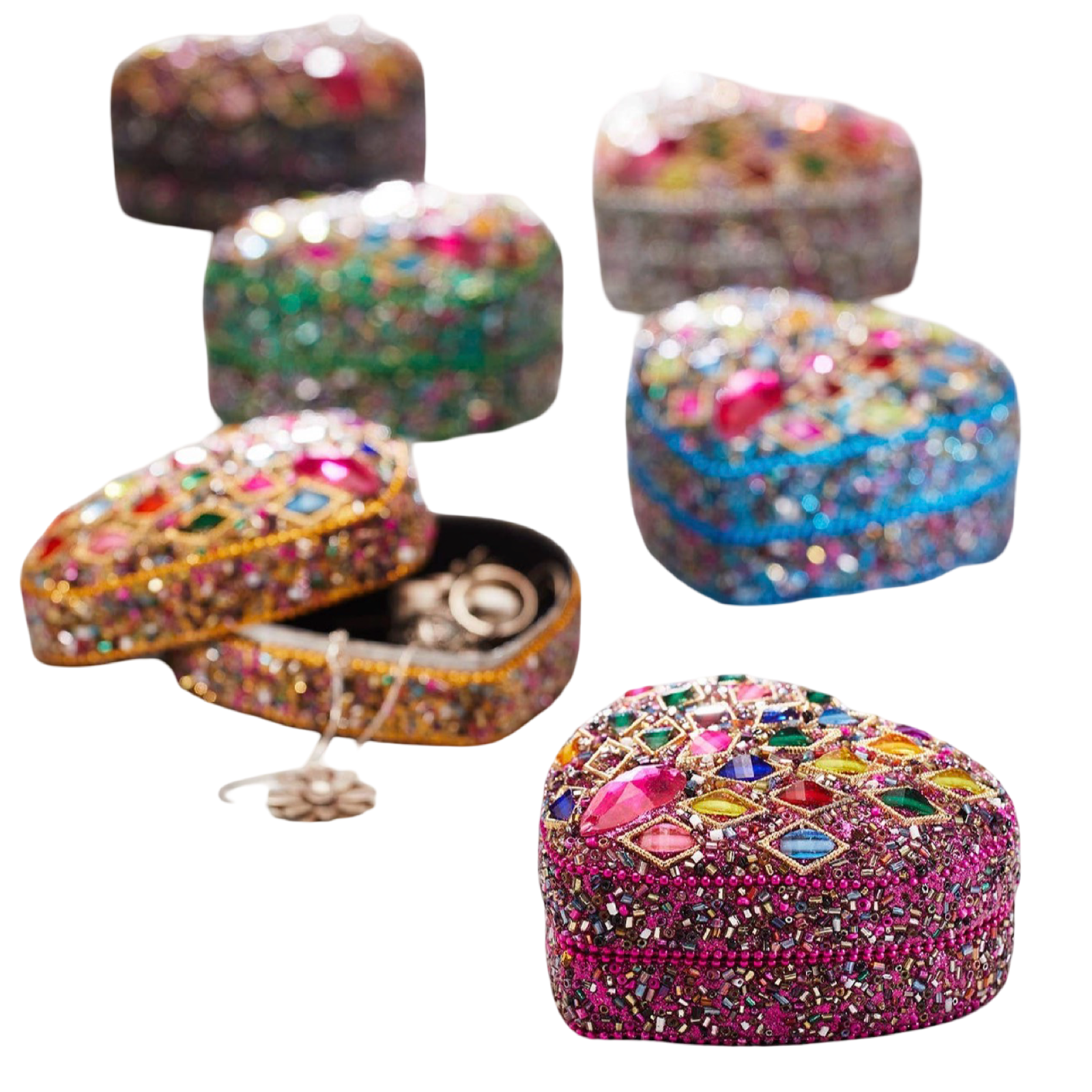 Five heart-shaped beaded jewelry boxes in different colors, decorated with colorful rhinestones and one open box showing rings inside, on a plain white background.