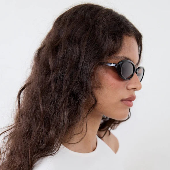 Woman wearing sunglasses with a plain white background
