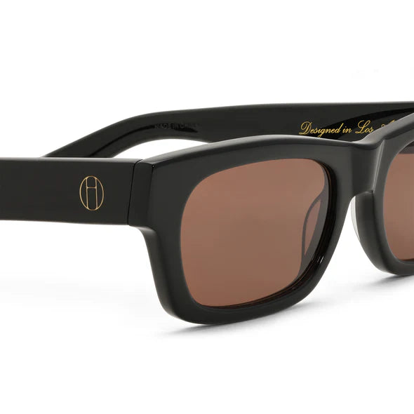 Black sunglasses with brown lenses on a white background