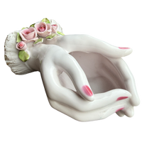 Decorative ceramic planter shaped like a woman's torso with floral hair on a white background