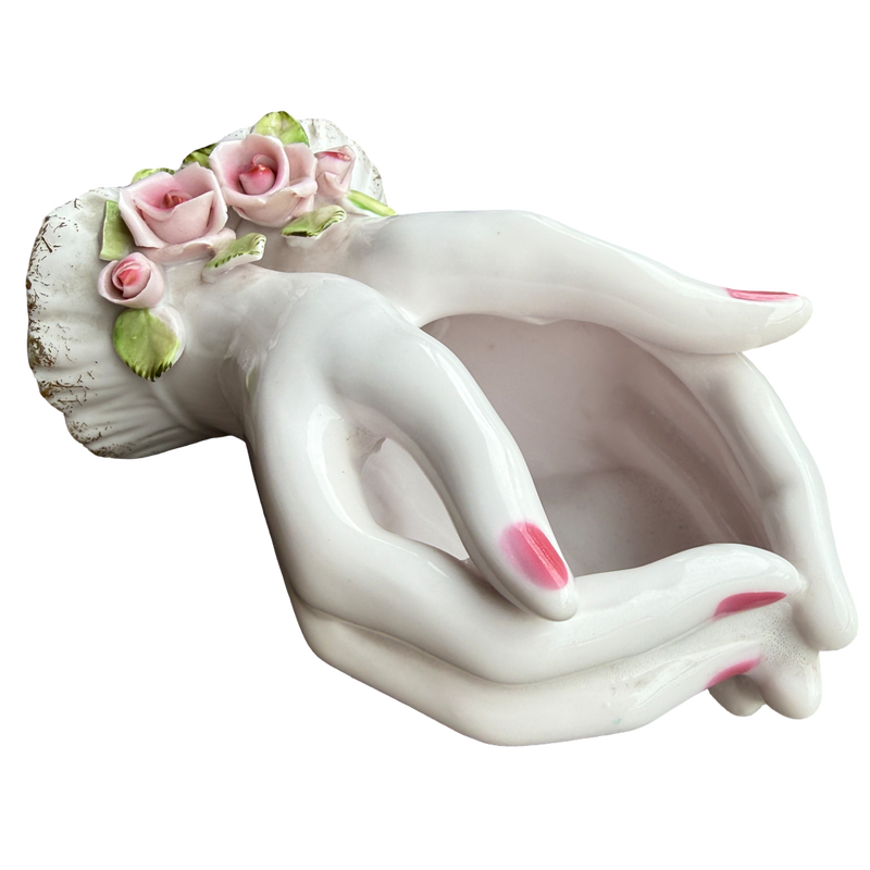 Decorative ceramic planter shaped like a woman's torso with floral hair on a white background