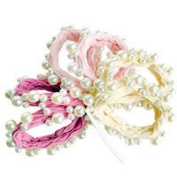 Two hair ties with pearl embellishments, one pink and one beige, on a white background.
