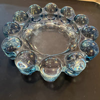 Clear glass dish with bubble design on a dark surface
