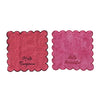 Two pink coasters with scalloped edges and text on a white background