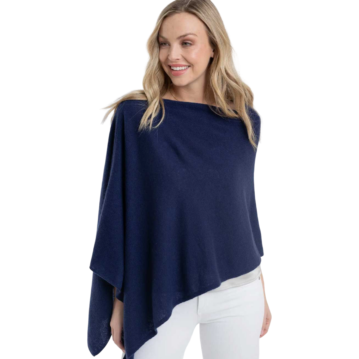Woman wearing a navy blue poncho over a white outfit on a white background