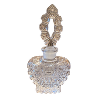 Decorative crystal perfume bottle with intricate design on a white background