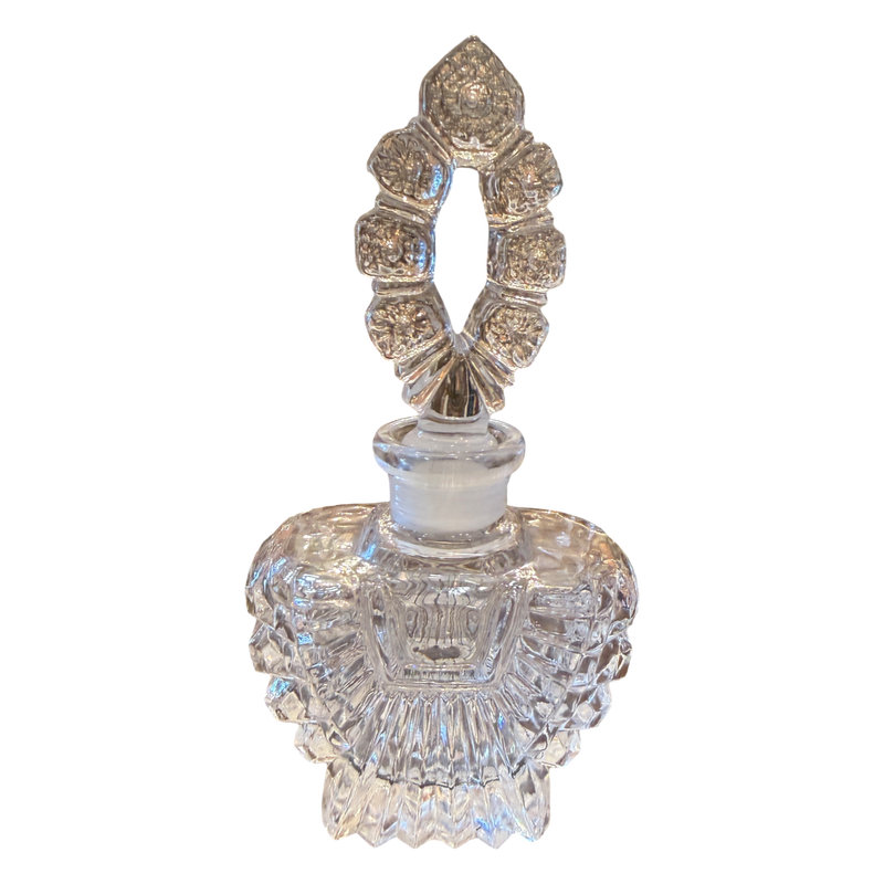 Decorative crystal perfume bottle with intricate design on a white background