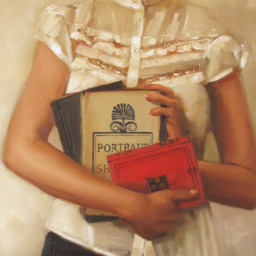 Person holding a red handbag and a book titled 'Portraits' with a blurred background