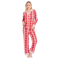 Woman wearing a red and pink star-patterned pajama set on a white background