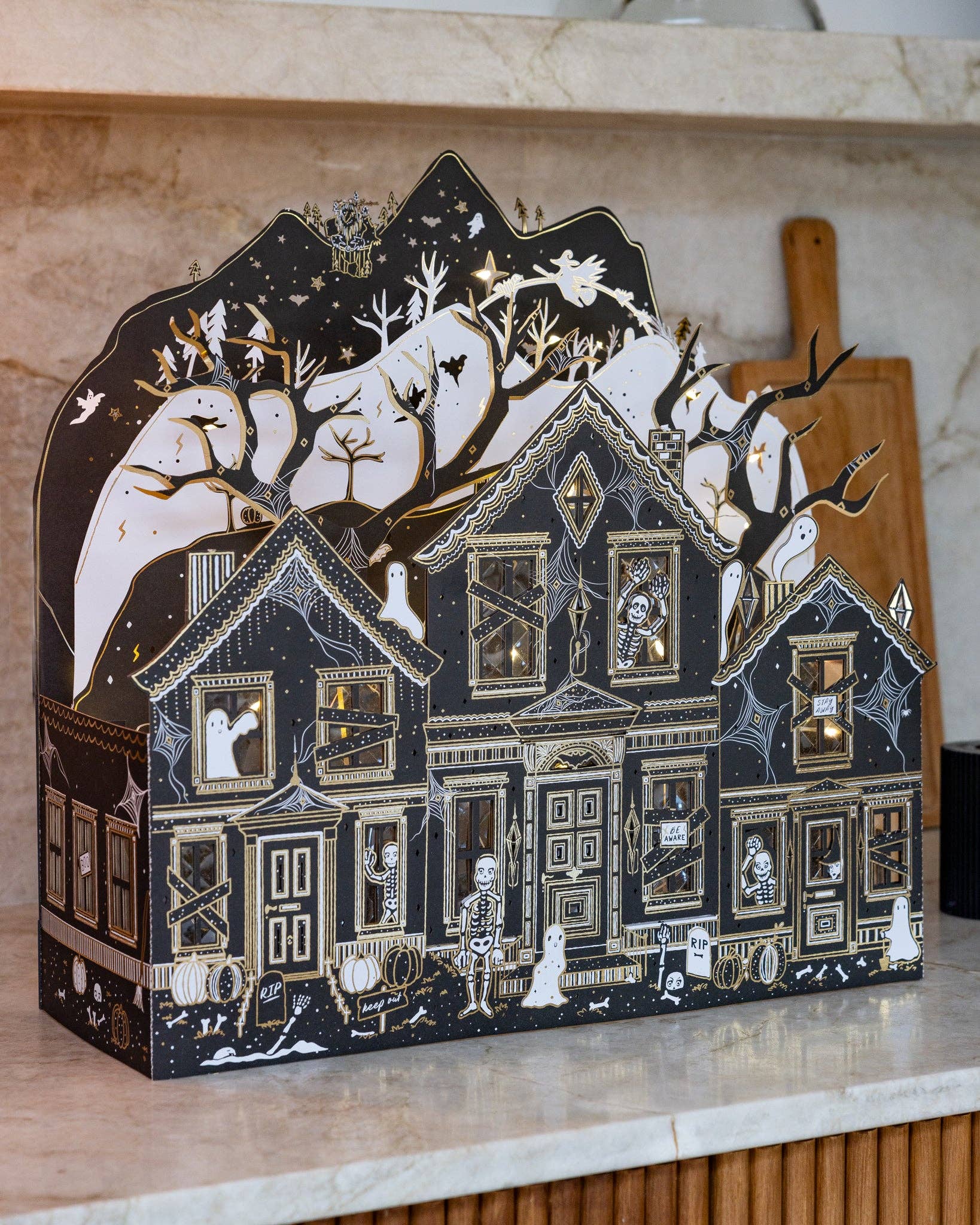 Decorative Halloween-themed house on a marble surface