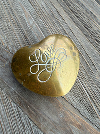 Gold stone with engraved script on a wooden surface