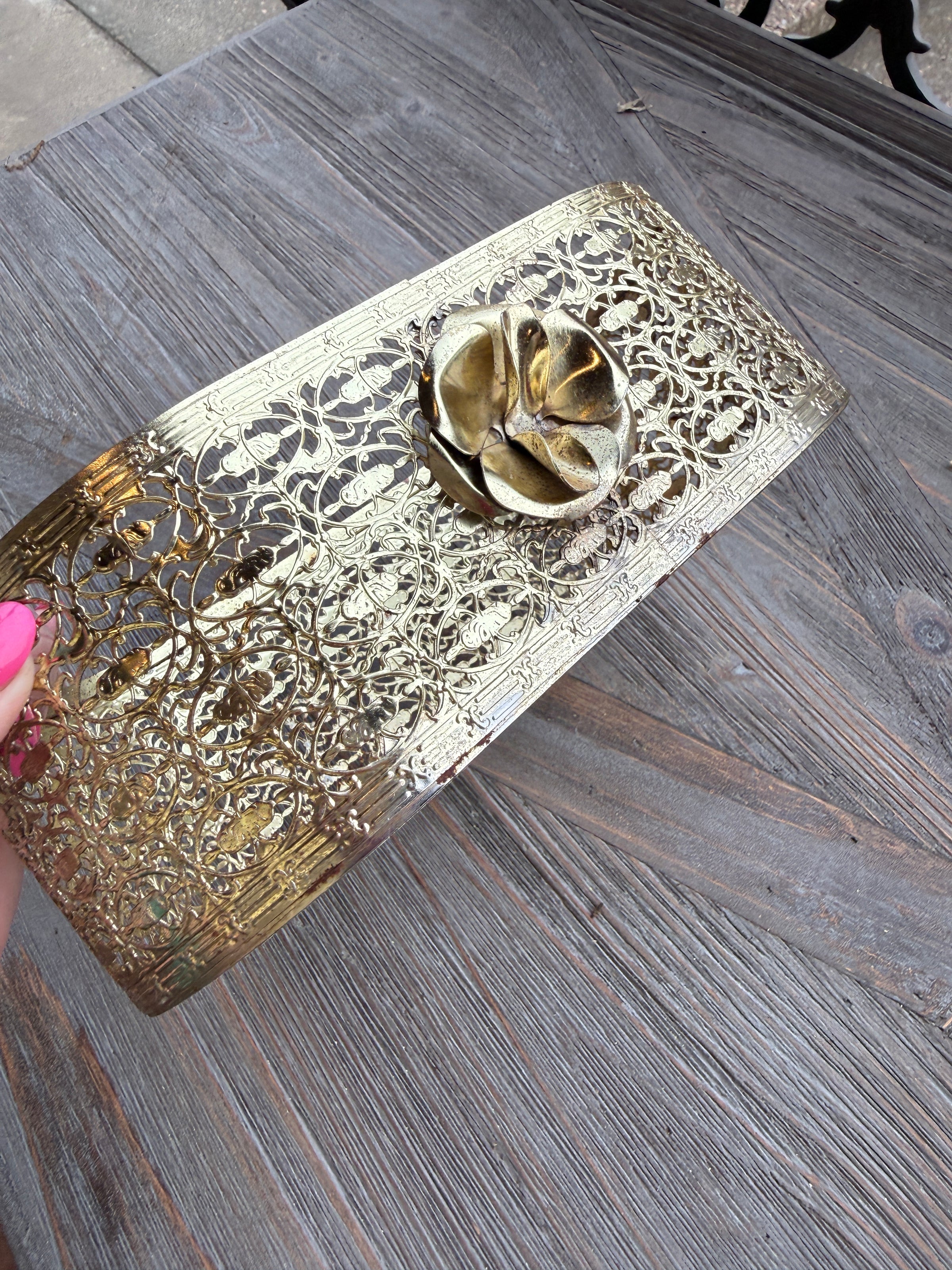 Decorative metallic object with intricate patterns on a wooden surface