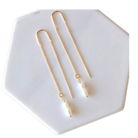 Gold necklace and earrings on a white hexagonal dish