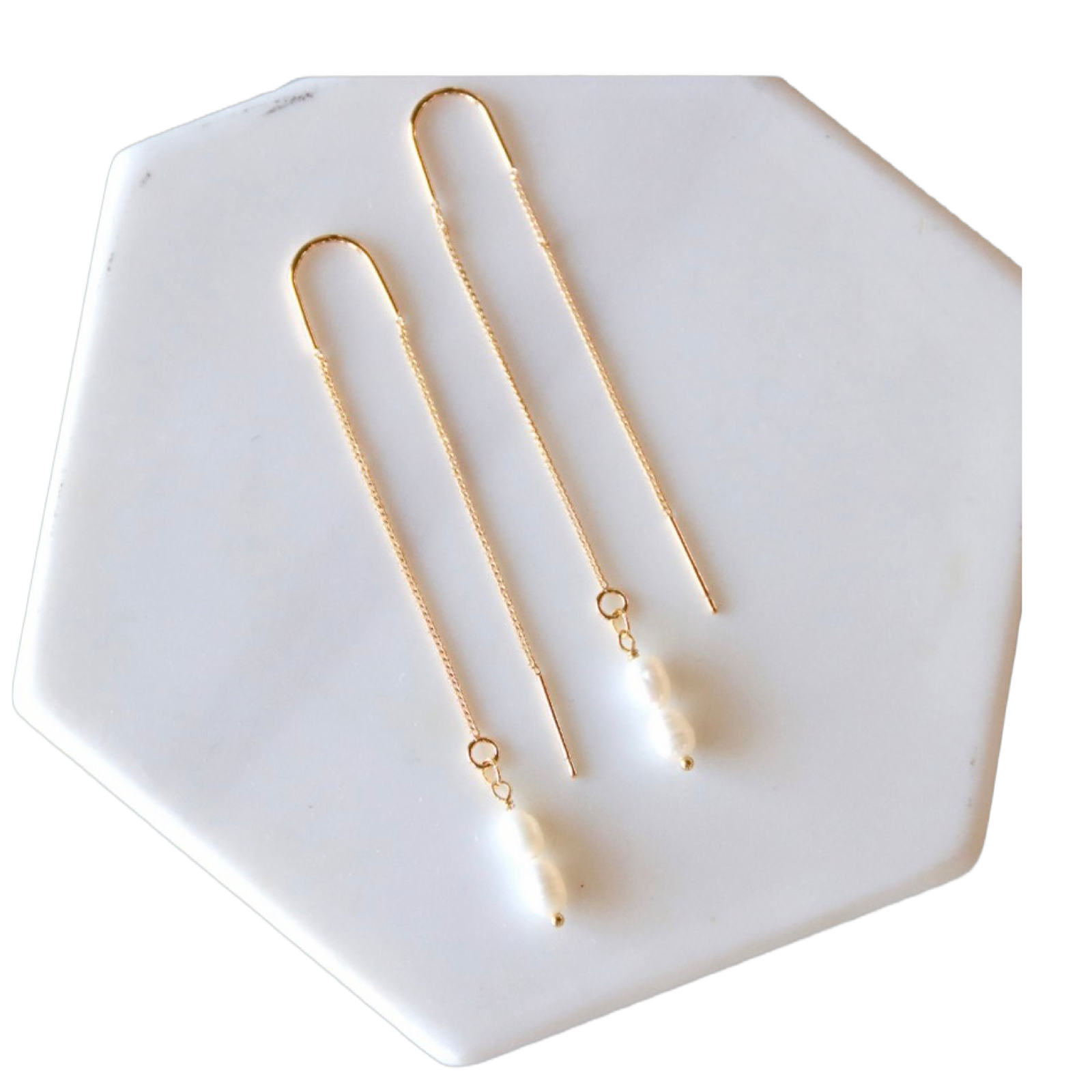 Gold necklace and earrings on a white hexagonal dish