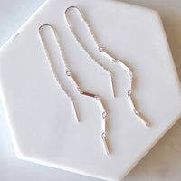 Silver necklace on a white hexagonal plate