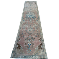 One-of-a-kind vintage Persian runner rug measuring approximately 2'11" x 12'5" with a faded dusty rose ground, blue and turquoise medallion motifs, ivory border and timeworn details.