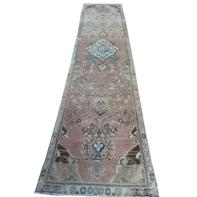 One-of-a-kind vintage Persian runner rug measuring approximately 2'11" x 12'5" with a faded dusty rose ground, blue and turquoise medallion motifs, ivory border and timeworn details.