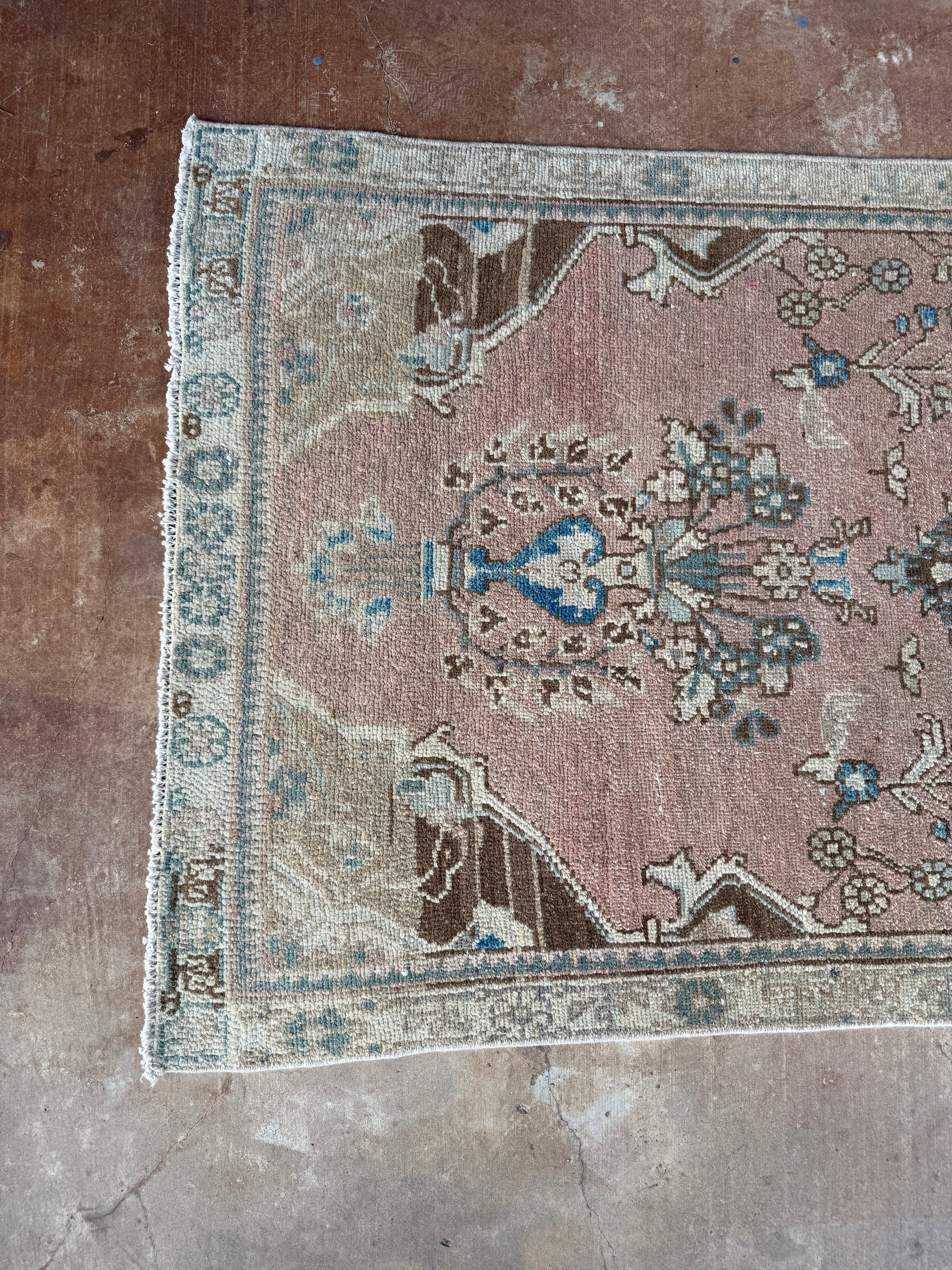 One-of-a-kind vintage Persian runner rug measuring approximately 2'11" x 12'5" with a faded dusty rose ground, blue and turquoise medallion motifs, ivory border and timeworn details.