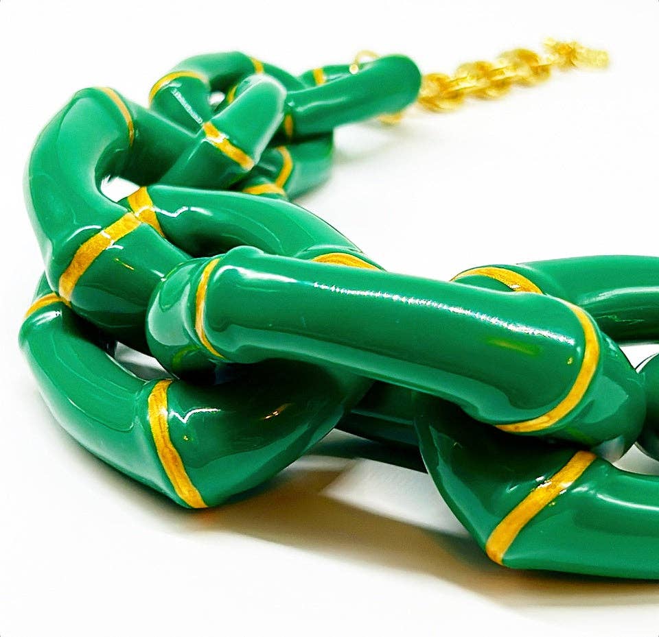 Green chain necklace with gold accents on a white background